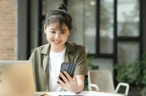 手机与电脑并排放在桌面上处理工作，出差路上用快连VPN 开会